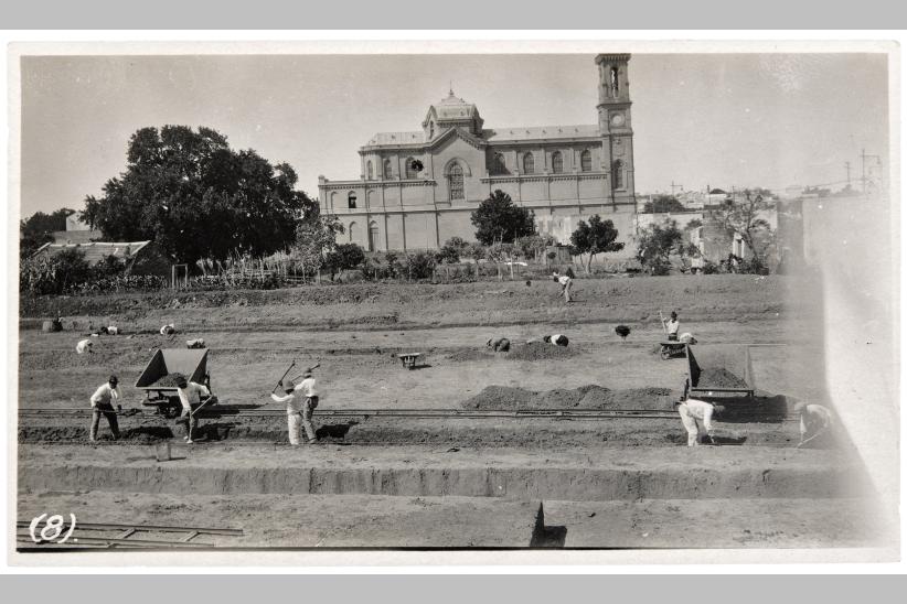Preparación del terreno para las franjas de cimentación. Al fondo, la Iglesia de Nuestra Señora de los Dolores, más conocida como Tierra Santa. Enero de 1921. Toma directa.