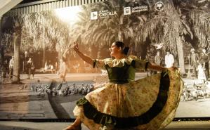 Mujer con vestido tradicional, bailando detrás hay un logo de la semana criolla