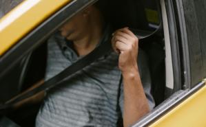 Hombre colocandose el cinturón de seguridad, el cual se destaca en la imágen.