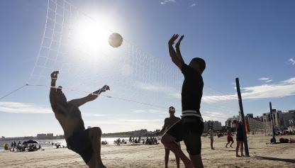 Personas jugando al voley en la playa.