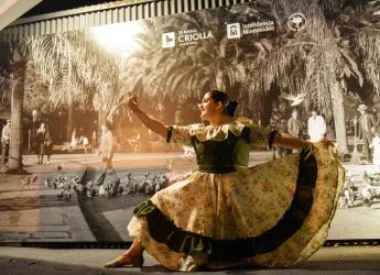 Mujer con vestido tradicional, bailando detrás hay un logo de la semana criolla